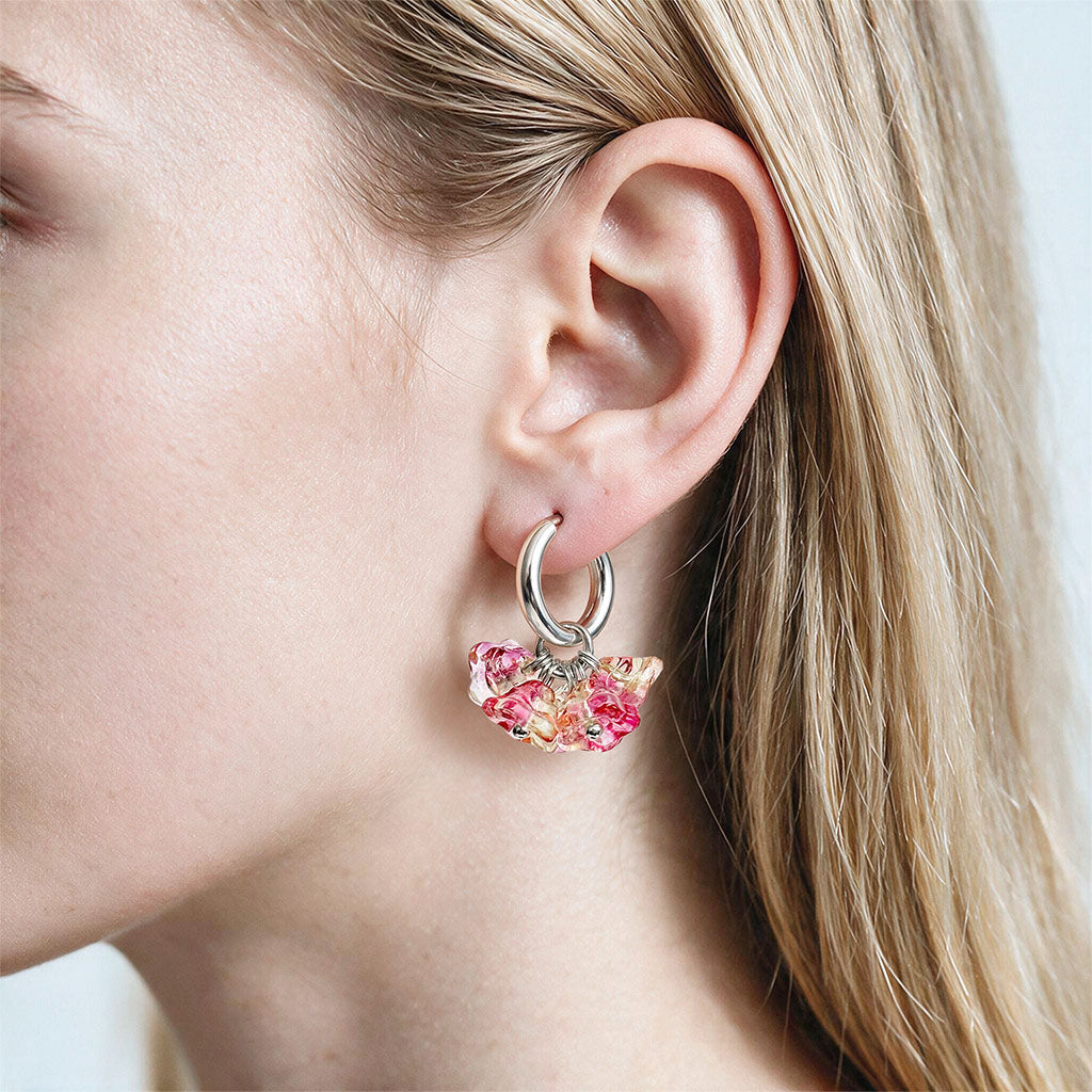 Woman wearing Bloom Sorbet glass flower earrings with huggie hoops, handcrafted in Finland by byMinta