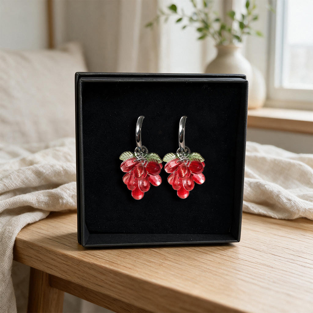 Red Currant Cluster Earrings presented in a black gift box with translucent red glass beads and gold-plated huggie hoops. Handcrafted in Finland.