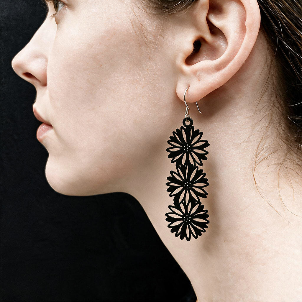 Black Asteria silicone earrings worn on ear, made in Finland