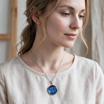 Woman wearing a handmade dandelion seed necklace with real dandelion seeds preserved in resin