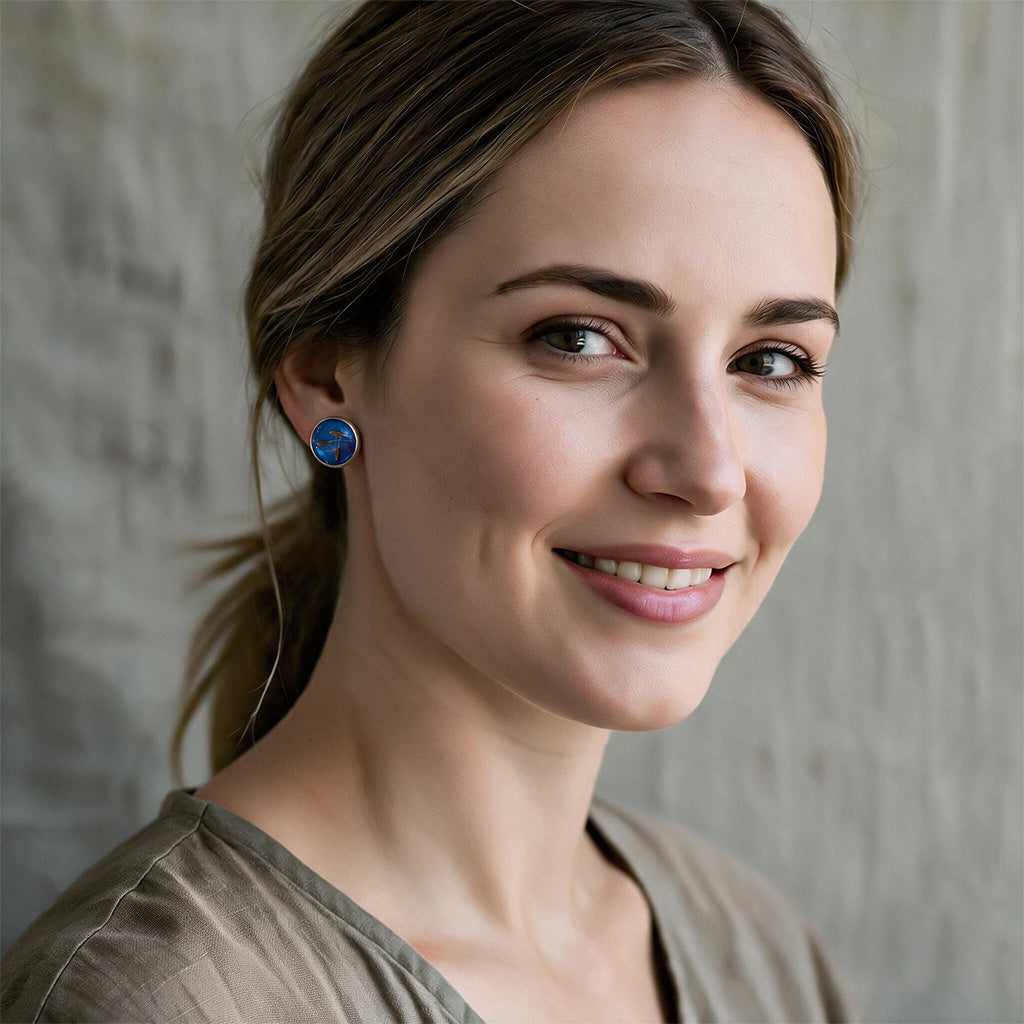 Woman wearing handmade dandelion seed stud earrings with real dandelion seeds preserved in resin, handcrafted in Finland.