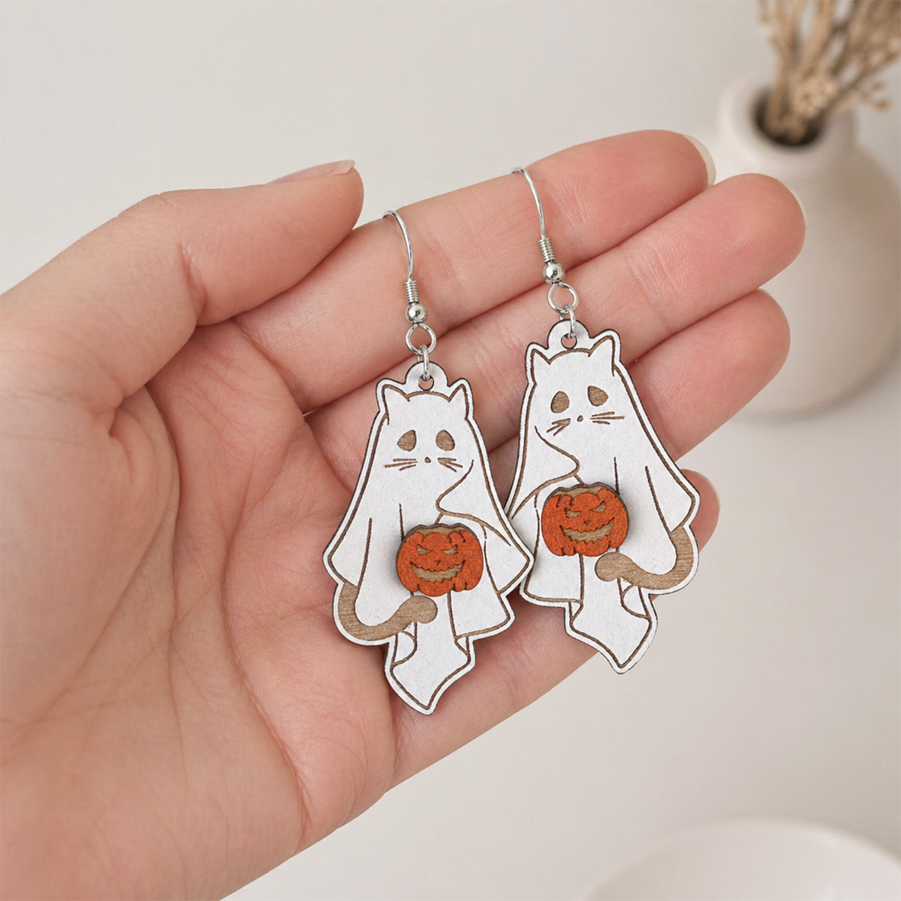 käsintehdyt Halloween kissa haamu korvakorut kädessä mittakaavan näyttämiseksi