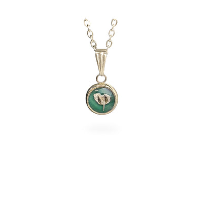Handmade round botanical necklace with a real baby's breath flower preserved inside resin. Delicate gold-tone pendant with a soft green background and fine chain on a clean white background, handcrafted in Finland.