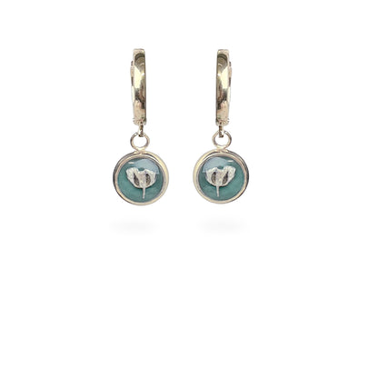 Delicate botanical huggie earrings with real white flowers and soft sage green background, handmade in Finland