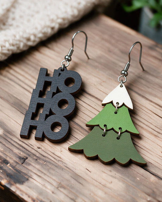 Ho Ho Ho Christmas tree earrings made in Finland, photographed on a wooden table in natural light