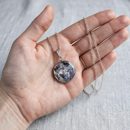 Hand holding handmade hydrangea necklace with real hydrangea flowers preserved in resin