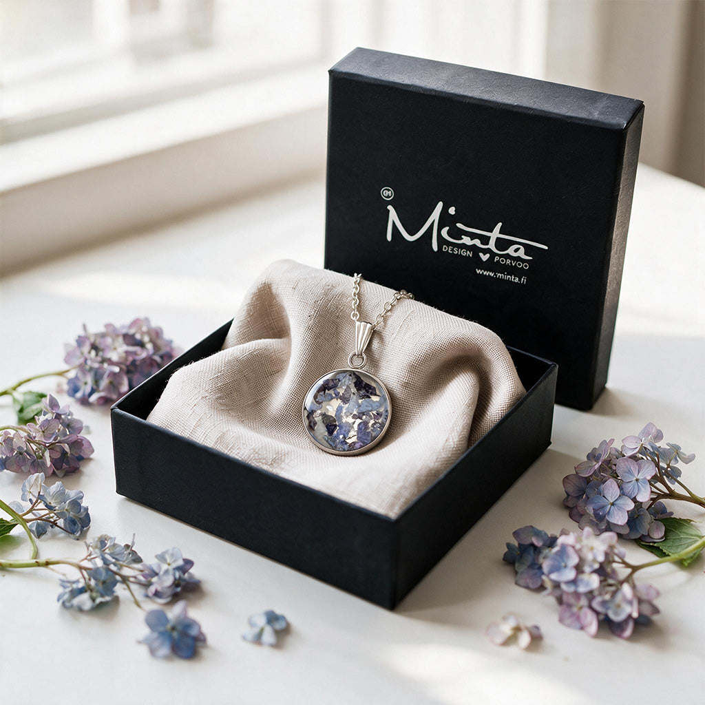Black jewelry box with a handmade hydrangea necklace featuring real hydrangea flowers preserved in resin