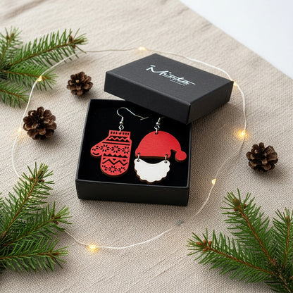 Christmas earrings presented in a gift box with pine branches, pinecones, and soft lights, creating a warm and festive holiday atmosphere. Handmade in Finland by byMinta.