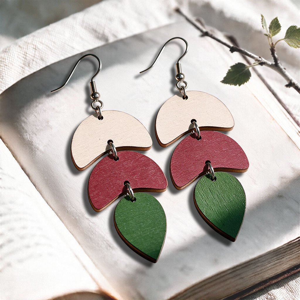 Multicolor Echo plywood earrings made in Finland, photographed on a vintage book in natural sunlight