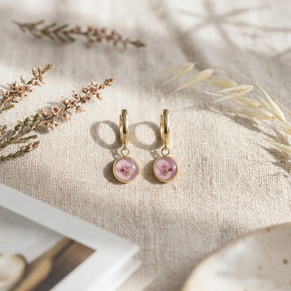 Pink heather flower huggie earrings on linen fabric with dried flowers, handmade Finnish jewelry