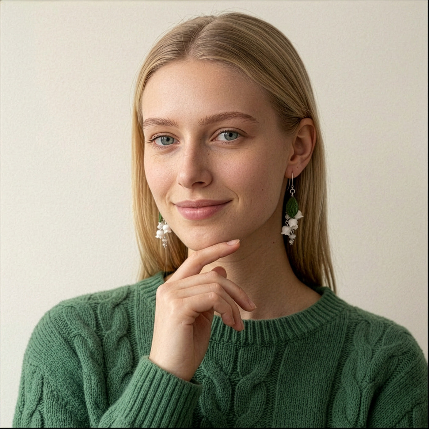 Woman wearing Lily of the Valley Earrings in a soft summer garden. Handmade floral earrings inspired by Finland’s national flower.