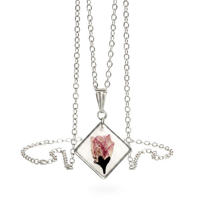 Minimalist cherry blossom necklace with real flower pendant and stainless steel chain on white background