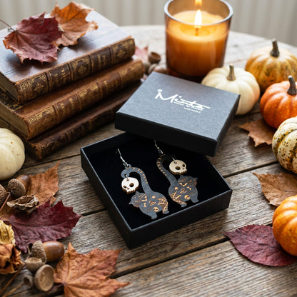 Black cat earrings with skull charms in byMinta gift box, handmade Halloween earrings from Finnish birch plywood.