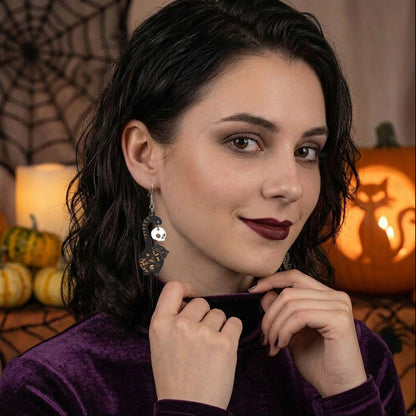 Black cat earrings with skull charms worn by a model, lightweight handmade Halloween earrings.