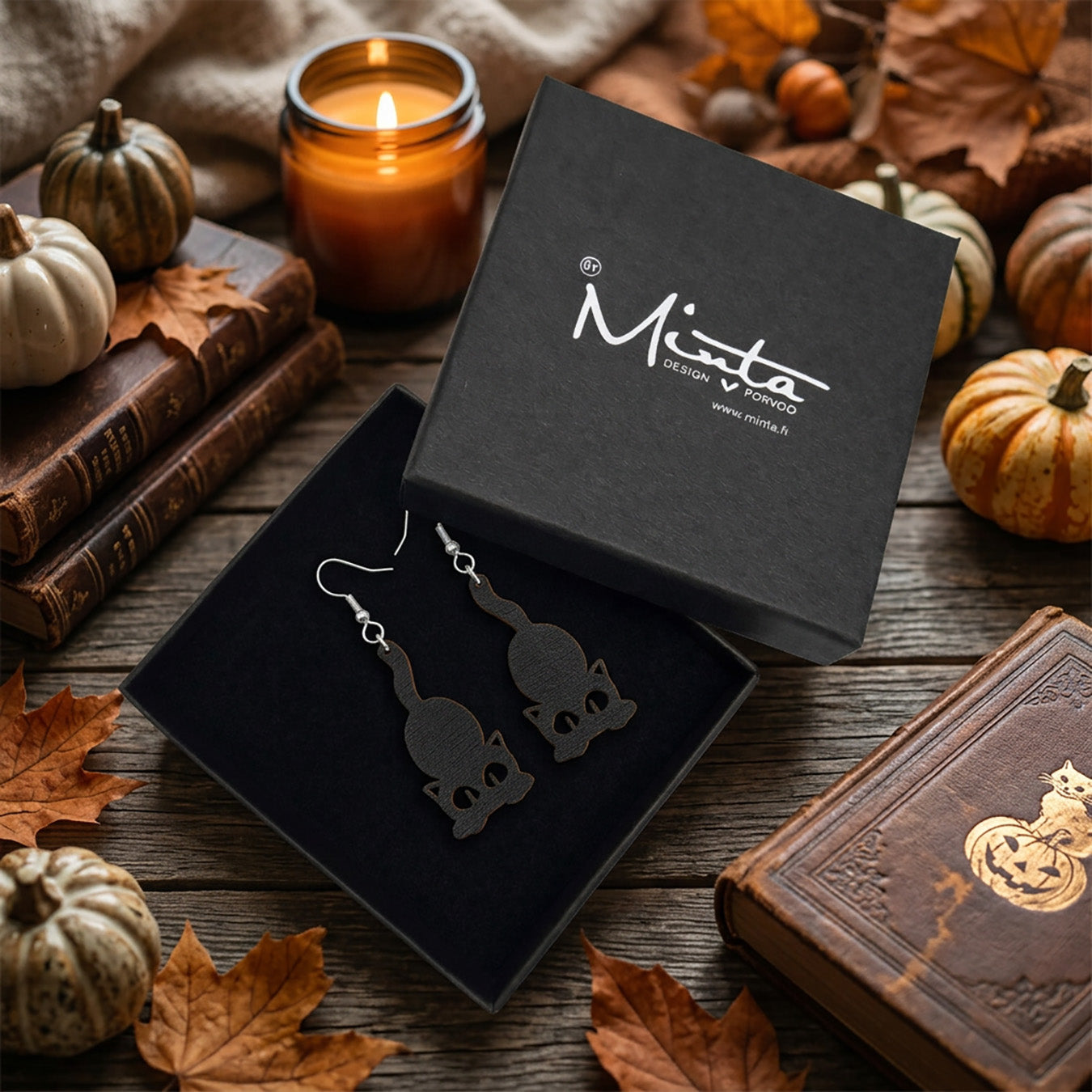 Black Cat Earrings in byMinta gift box with autumn leaves and Halloween decorations.