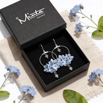 Light Blue Flower Vine Hoop Earrings presented in a gift box, surrounded by natural linen fabric and delicate blue flowers. Handmade in Finland by byMinta.