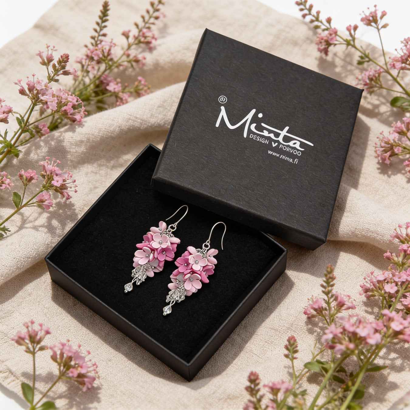 Flower Cloud Earrings presented in a gift box, surrounded by natural linen fabric and airy pink flowers. Handmade in Finland by byMinta.