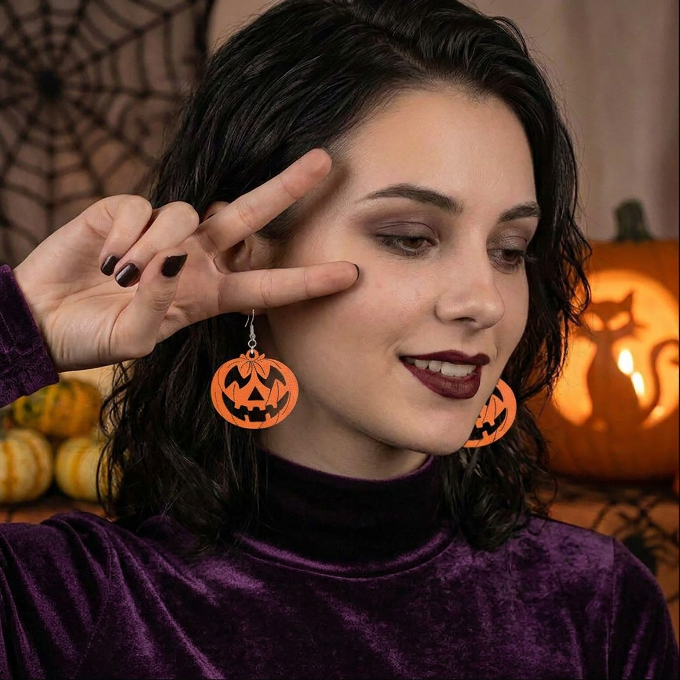 Pumpkin earrings worn by a model, lightweight handmade Halloween earrings.