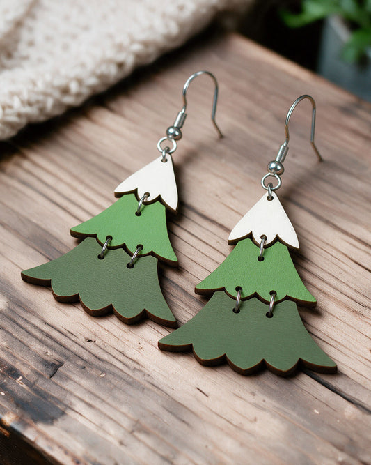 Christmas tree earrings made in Finland, photographed on a wooden table in natural light