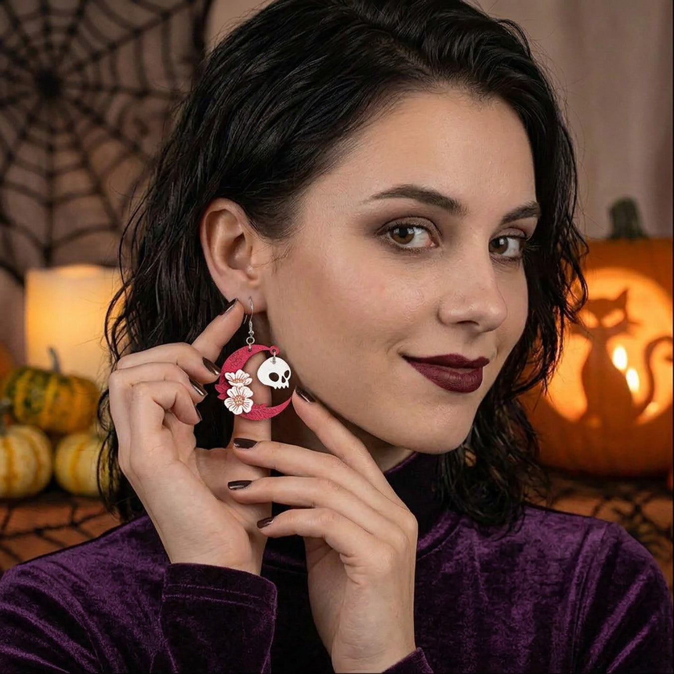 Woman wearing pink crescent moon and skull earrings with floral details, lightweight handmade wooden earrings