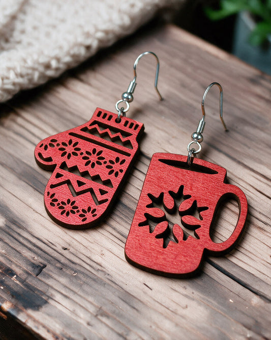 Christmas mitten and mug earrings made in Finland, photographed on a wooden table in natural light