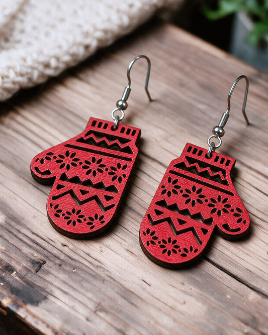Christmas mitten earrings made in Finland, photographed on a wooden table in natural light
