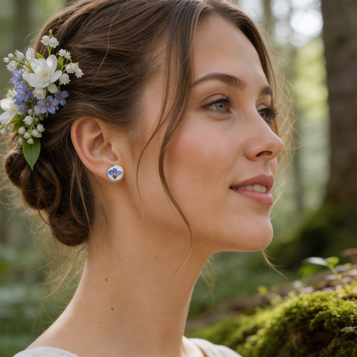 Woman wearing forget-me-not stud earrings by byMinta in a soft Nordic forest setting with delicate blue flowers and natural summer light.
