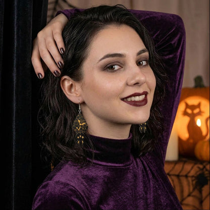 Woman wearing Spider Web Bat Earrings in a stylish Halloween portrait.