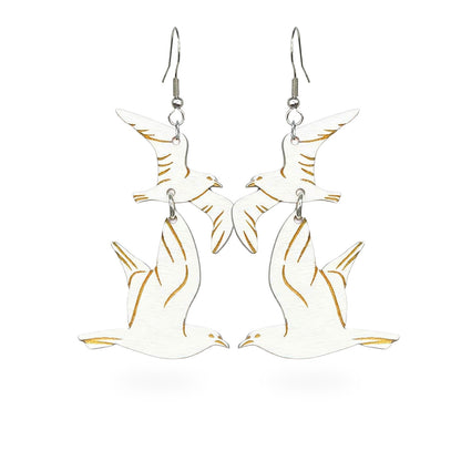 Handmade white seagull earrings crafted from Finnish birch plywood. Lightweight statement earrings featuring soaring seagulls with engraved details and a coastal Nordic-inspired design.