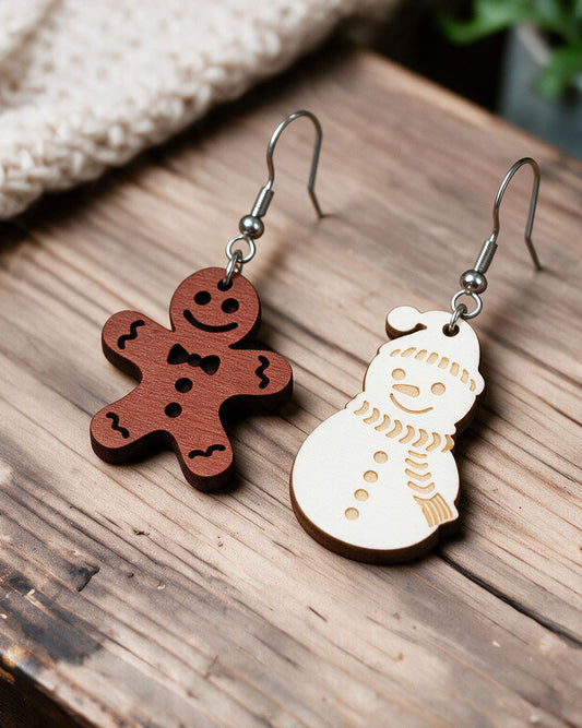 Snowman and Christmas elf earrings made in Finland, photographed on a wooden table in natural light