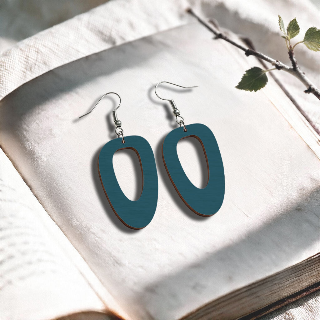 Bluepetrol Islet plywood earrings made in Finland, photographed on a vintage book in natural sunlight
