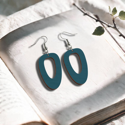 Bluepetrol Islet plywood earrings made in Finland, photographed on a vintage book in natural sunlight