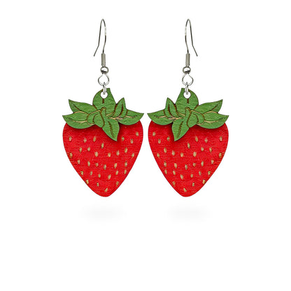 Handmade strawberry earrings crafted from Finnish birch plywood. Lightweight red berry earrings with engraved seed details and playful Nordic-inspired design.