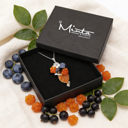 Berry Forest Necklace presented in a gift box, surrounded by natural linen fabric, fresh blueberries, black currants, cloudberries, and green leaves in soft natural light. Handmade necklace with hand-shaped berries and leaves, handmade in Finland by byMinta.