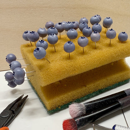 Hand-shaped blueberry components in the making, carefully sculpted and drying before assembly into Blueberry Bouquet Earrings. Handmade in Finland by byMinta.