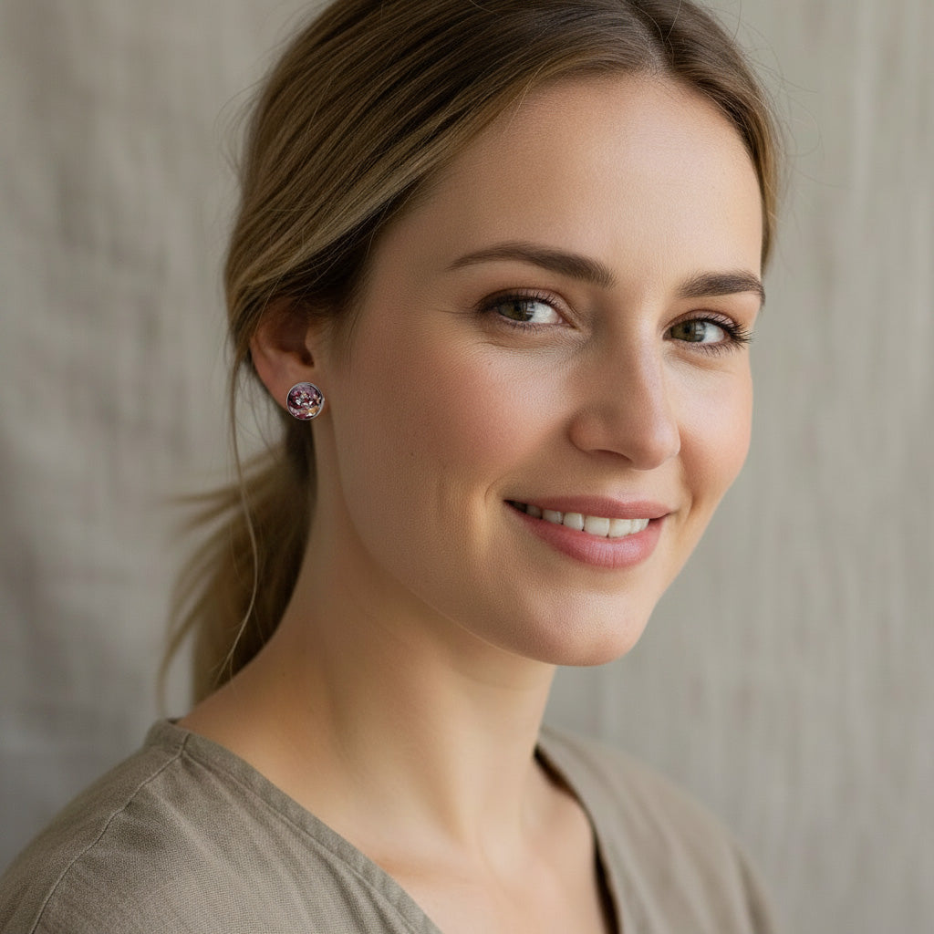 Nordic woman wearing handmade rose petal stud earrings with real preserved rose petals and silver leaf, handcrafted in Finland.