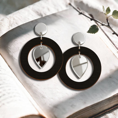 Black NiinMua birch plywood stud earrings with silver mirror acrylic drops, made in Finland, photographed on a light neutral background.
