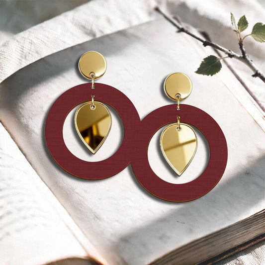 Rust NiinMua birch plywood stud earrings with gold mirror acrylic drops, made in Finland, photographed on a light neutral background.
