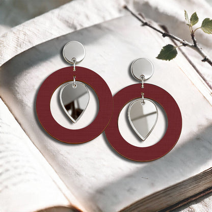 Rust NiinMua birch plywood stud earrings with silver mirror acrylic drops, made in Finland, photographed on a light neutral background.