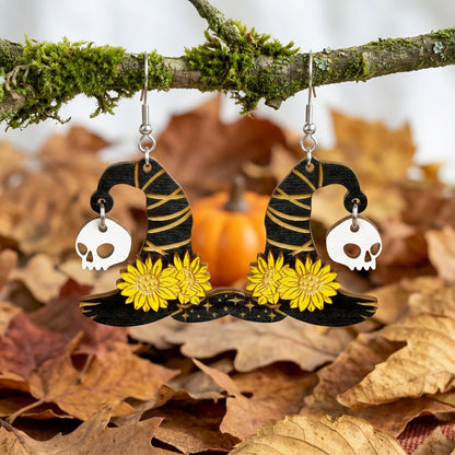 Witch Hat Earrings hanging from a moss-covered branch among autumn leaves.