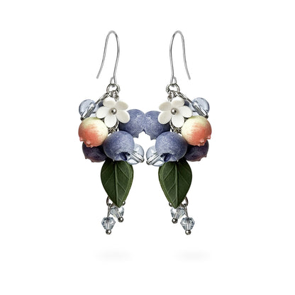 Blueberry Branch Earrings featuring hand-shaped blueberries, delicate white flowers, crystal details, and green leaves. Handmade in Finland by byMinta.