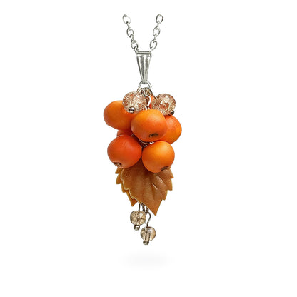 Handmade berry necklace featuring sculpted rowan berries, a warm amber-toned leaf and sparkling crystal beads. Botanical statement jewelry on a fine chain against a clean white background, handcrafted in Finland.