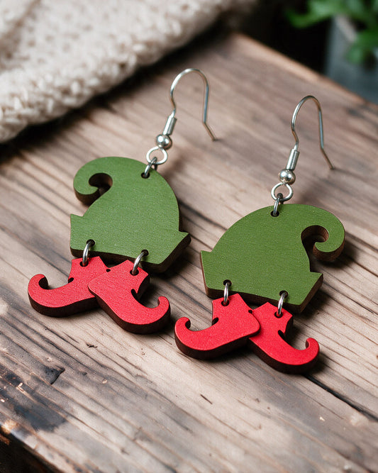 Playful Christmas earrings made in Finland, photographed on a wooden table in natural light