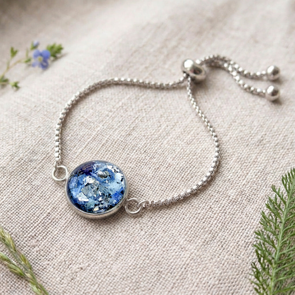 Handcrafted stainless steel bracelet featuring real hydrangea petals preserved in clear resin on fine linen. Made in Finland by byMinta.