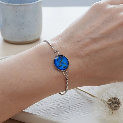 Handcrafted dandelion seed bracelet with a real dandelion seed worn on a wrist.