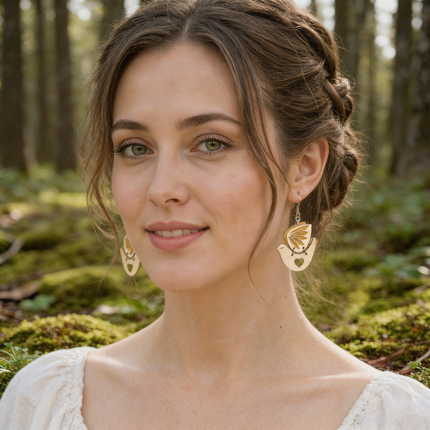 Laser-cut wooden bird earrings by byMinta with layered leaf details and heart-shaped cutouts, handmade in Finland.