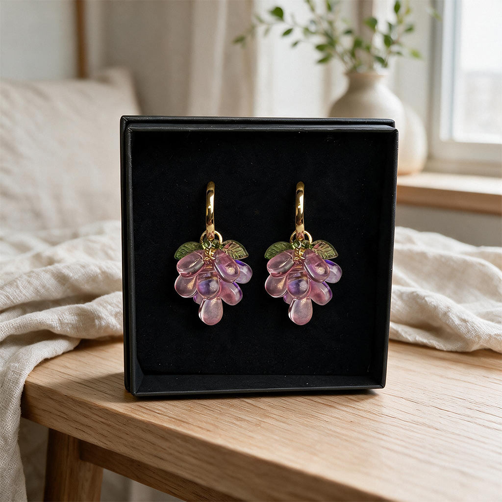 Plum Cluster Earrings presented in a black gift box with translucent purple glass beads and gold-plated huggie hoops. Handcrafted in Finland.