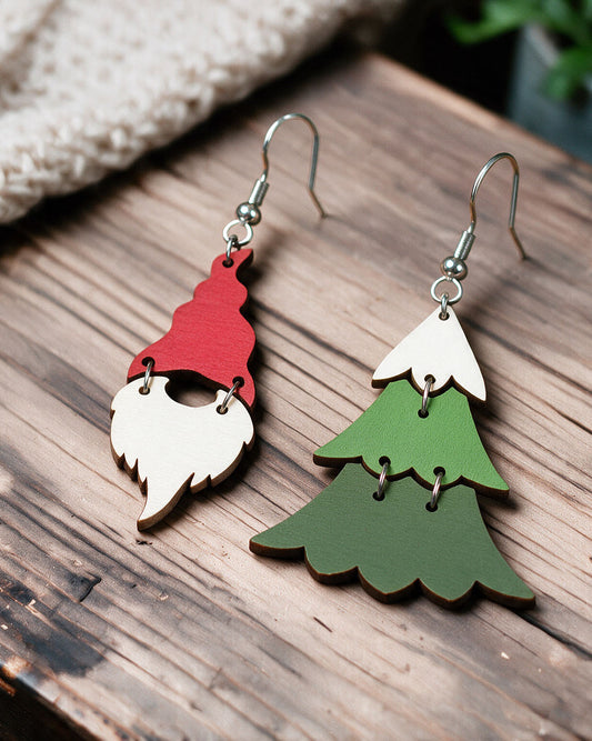 Christmas elf and tree earrings made in Finland, photographed on a wooden table in natural light
