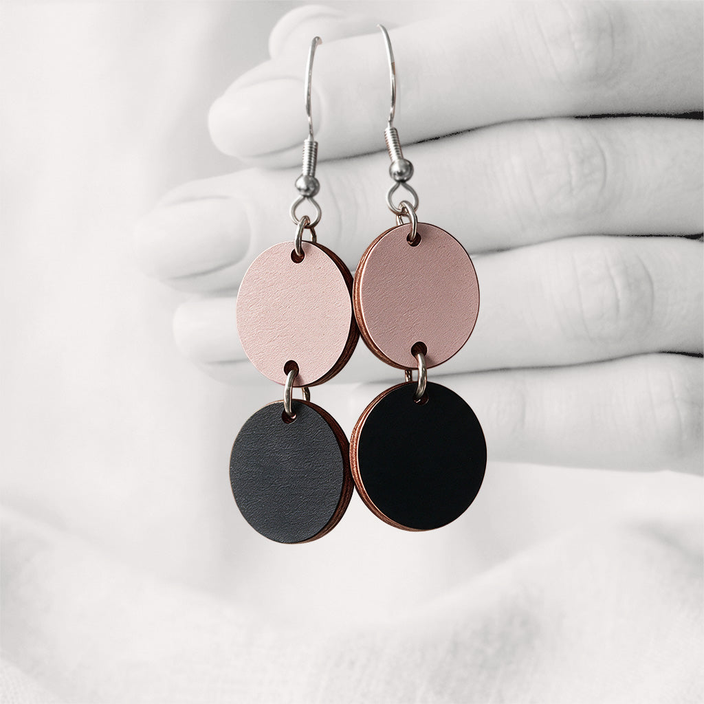Black and powder Tuplakupla duo plywood earrings handmade in Finland, featuring two round wooden pieces on stainless steel hooks