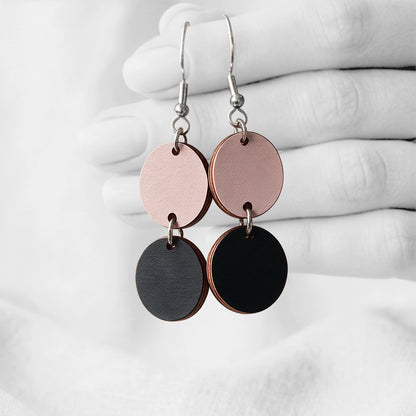 Black and powder Tuplakupla duo plywood earrings handmade in Finland, featuring two round wooden pieces on stainless steel hooks